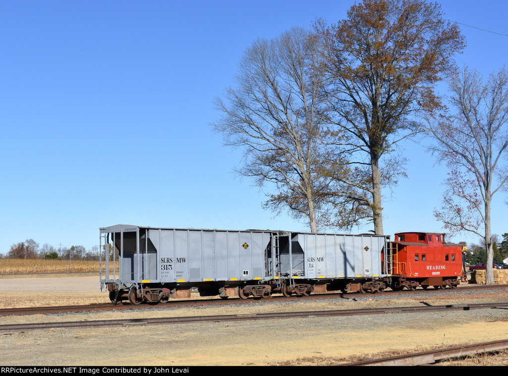 Two hopper cars and a restored Reading Caboose waiting to be coupled to the 0-6-0 9 steam locomotive in Woodstown around the S. Woodstown Station. 